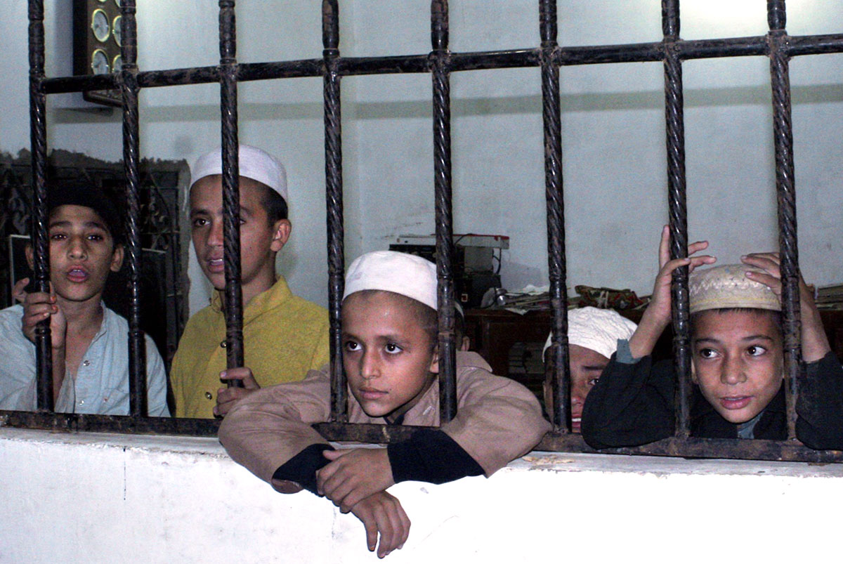 Iskolásgyerekek nézelődnek azt követően, hogy pakisztáni rendőrök kimentették őket egy muzulmán vallási iskolából