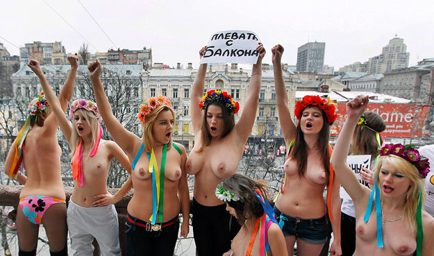 A FEMEN félmeztelen aktivistái jelszavakat kiáltoznak egy kijevi lakóház erkélyéről. Fehéroroszországban nem látják szívesen őket