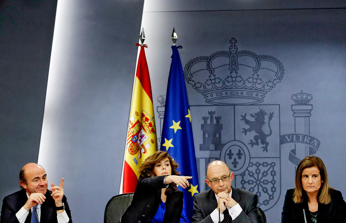 Soraya Saenz de Santamaría (középen) kezében az irányítás: mellette De Guindos (balról) gazdasági, Montoro pénzügy- és Banez munkaügyi miniszter magyarázza a csomagot