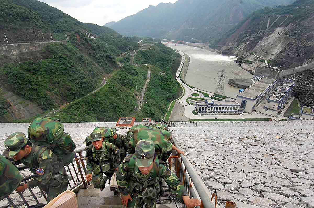 Katonák a Zipingpu-gátnál, melynek víztömege egyes kutatók szerint összefüggésbe hozható a 2008-as szecsuáni földrengéssel