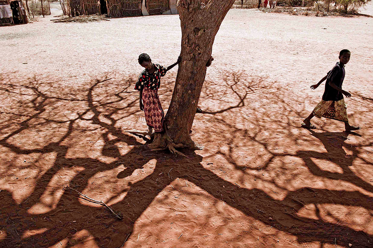 Egy fiú áll egy fa mellett, 2011 júliusában az éhínség sújtotta Kelet-Afrikában. A kenyai és etiópiai éhezők száma folyamatosan nő