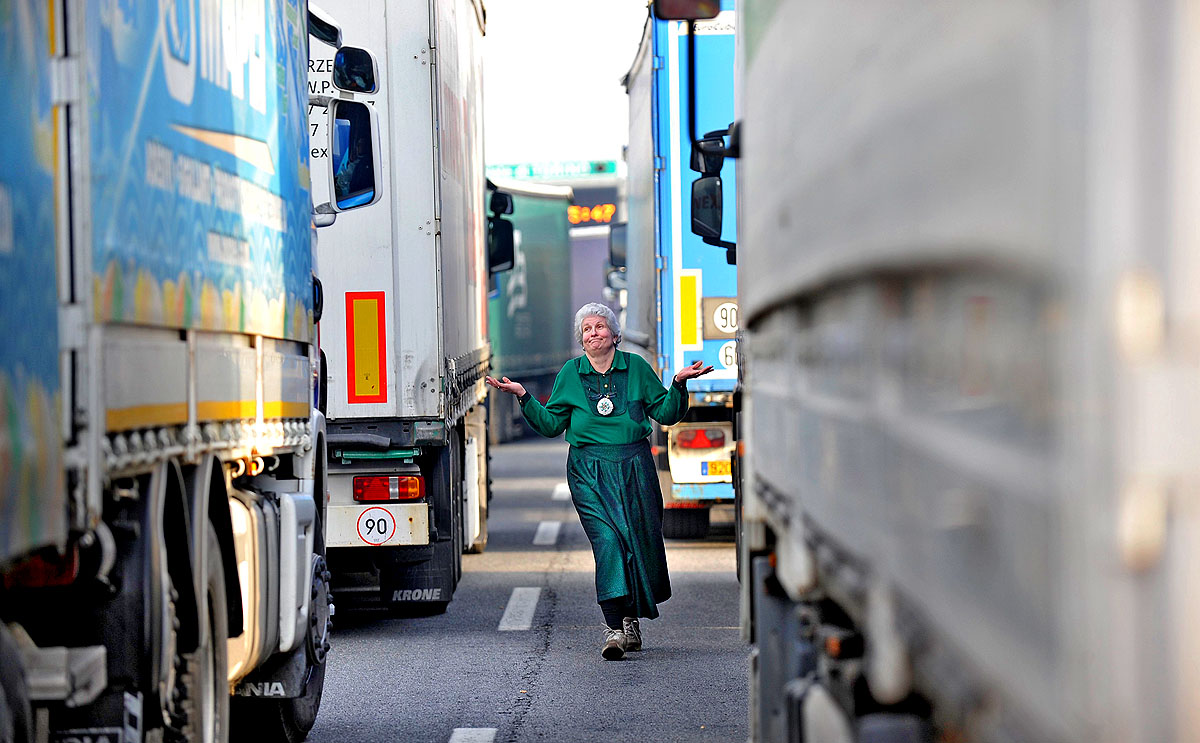 Egy Monica nevű német teherautó-sofőr integet értetlenkedve egy Torino környéki dugóban, amelyet kollégái, a kormányintézkedések ellen tiltakozó olasz kamionvezetők sztrájkja okozott