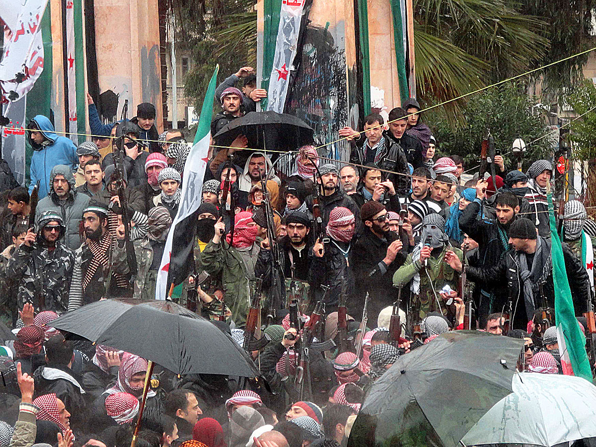 A dezertőrökből álló Szabad Szíriai Hadsereg (FSA) katonái az ellenzéki tüntetők között Idlib városában