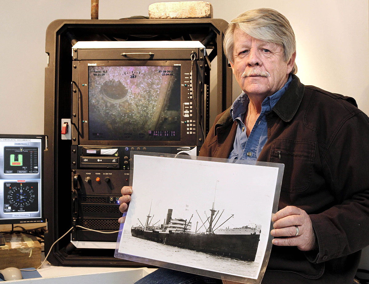 Greg Brooks, a Sub Sea Research társigazgatója egy, a Port Nicholson brit kereskedelmi hajóról készült fényképet tart a kezében a Sea Hunter mentőhajón