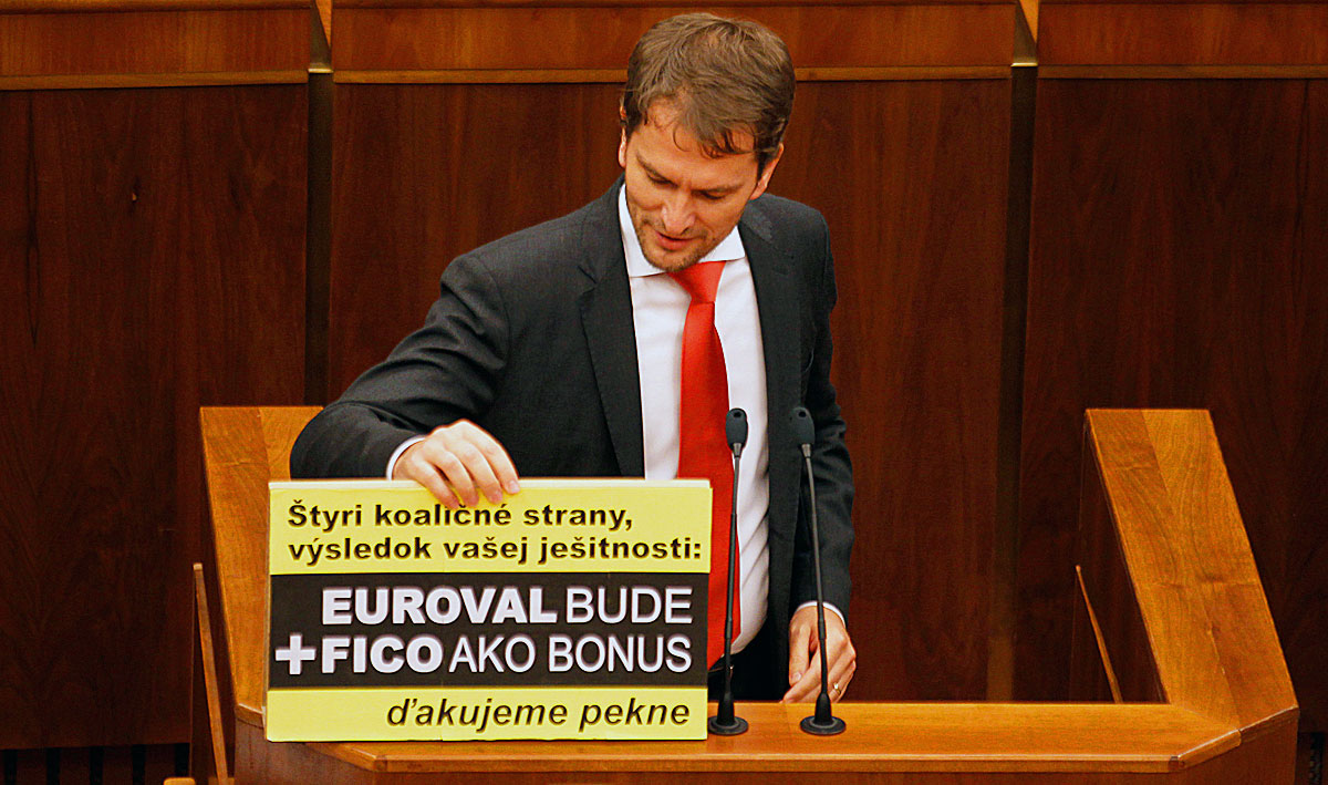 Member of Slovak Parliament Igor Matovic displays a banner during a repeated vote on the euro zone rescue fund, at the Slovak Parliament in Bratislava, October 13, 2011. The banner reads: 