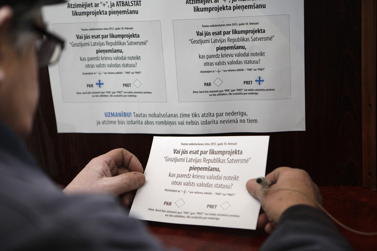 Szavazólap egy lettországi polgár kezében - a jövőben is egy nyelven lesz csak rajta a kérdés