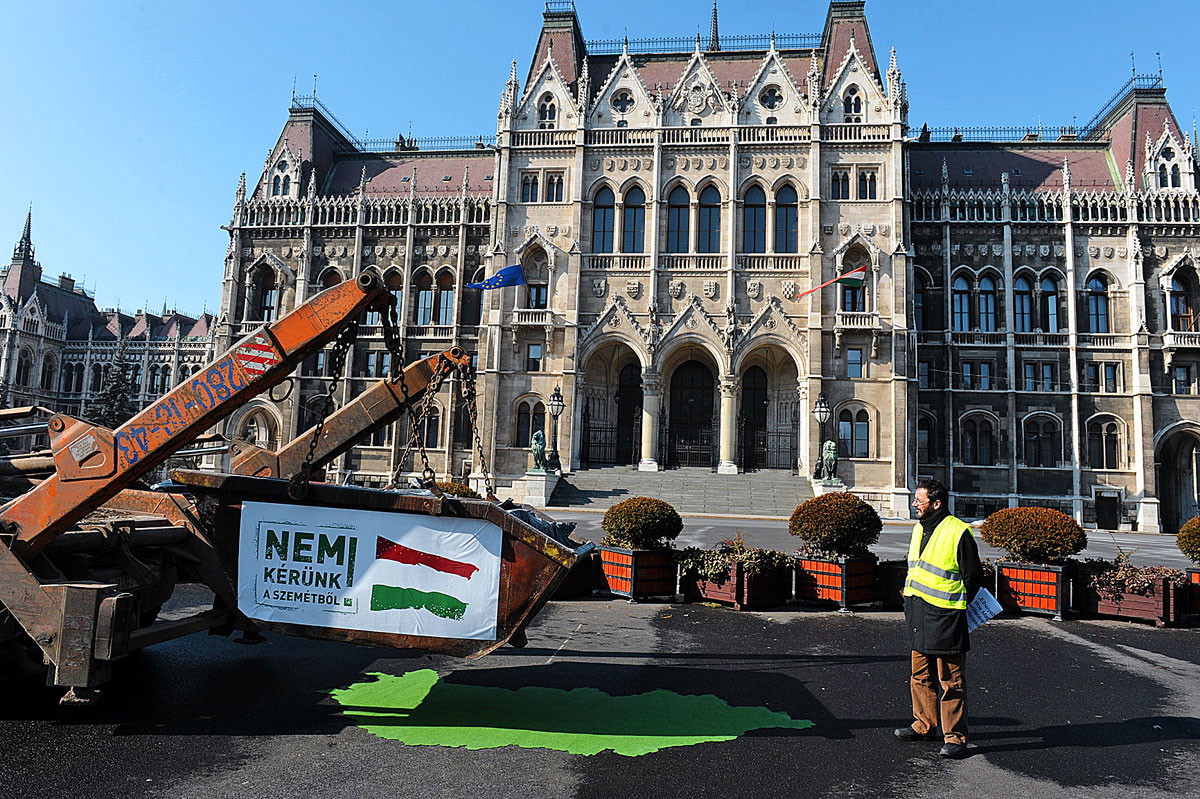 A sajtótájékoztató idején az LMP aktivistái egy teherautó platójáról, egy zöld filcből kivágott Magyarország térképre raktak egy sitteszsákokkal teli szemeteskonténert.