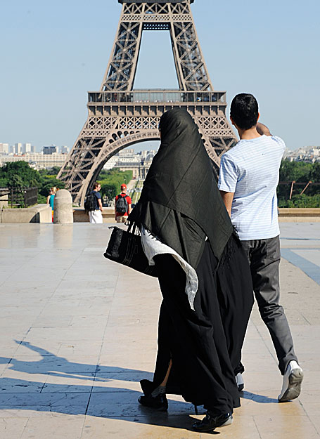 A woman wearing a niqab walks at Trocadero square near the Eiffel Tower in Paris June 24, 2009. Nearly 60 legislators signed a proposal calling for a parliamentary commission to look into the spread of the burqa in France, a garment that they said am