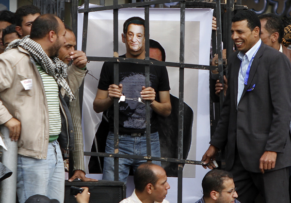 Egy tüntető Mubarak-álarccal, bilincsben - a Tahrir tér hősei hetek óta követelik a volt egyiptomi elnök letartóztatását