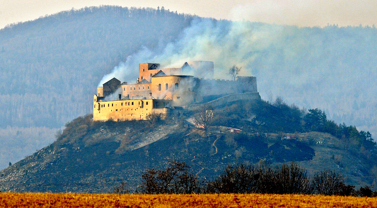Sűrű füst száll a magasba a krasznahorkai várból, Rozsnyó közelében