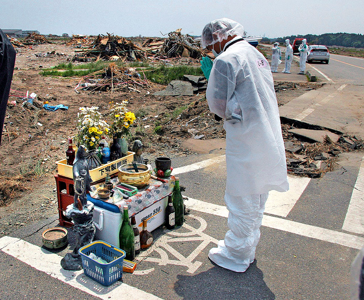 Egy a fukusimai atomerőmű 20 km-es körzetéből kitelepített helyi lakos imádkozik a földrengés és a cunami áldozataiért tavaly májusban