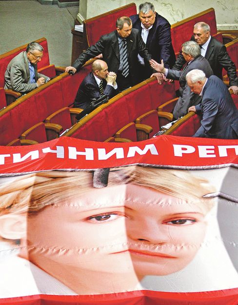 Ukrán ellenzéki képviselők Timosenko kiterített óriásplakátjával a kijevi törvényhozásban.