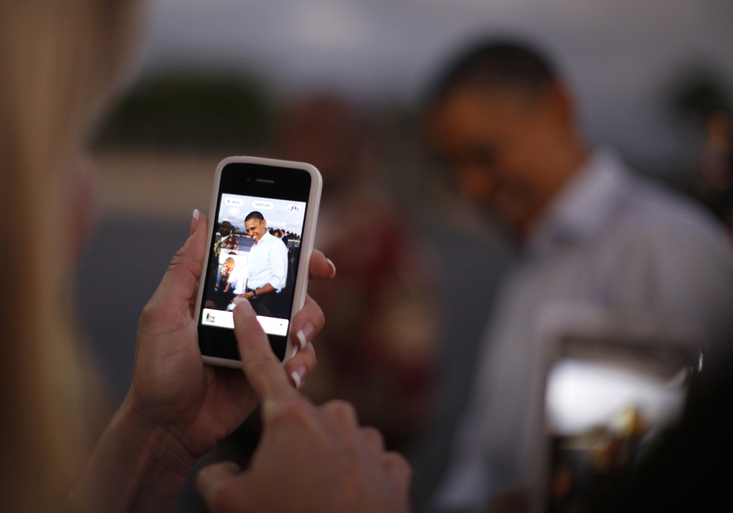 Egy nő fényképet készít mobiljával az amerikai elnökről. Az Obama-stáb a választók álmaiban is olvasni akar