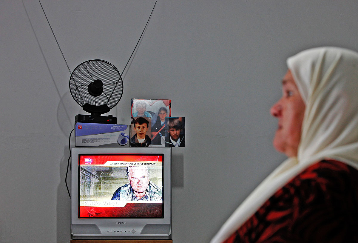 Mejra Dzogaz tévét néz a Srebrenica melletti Potocariban. A bosnyák asszonynak a férjét, három fiúgyermekét és egy unokáját ölték meg 1995-ben a szerbek