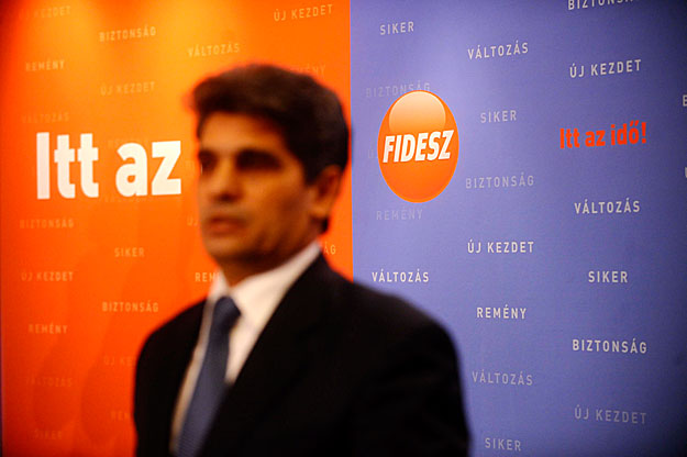 Farkas Flórián miniszteri biztosként nyilatkozik pártja logója előtt
