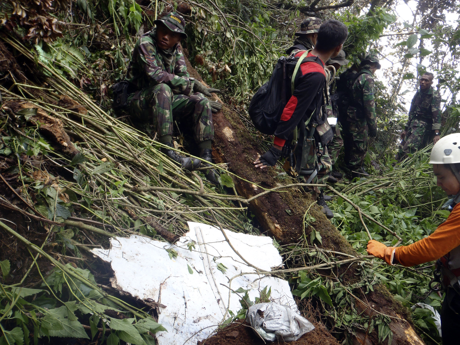 An Indonesian soldier, part of a rescue team, sits near the wreckage of a Russian Sukhoi aircraft on the slope of Mount Salak, near Bogor May 11, 2012. A rescue team found no survivors but several bodies on Thursday when it arrived at the wreckage of