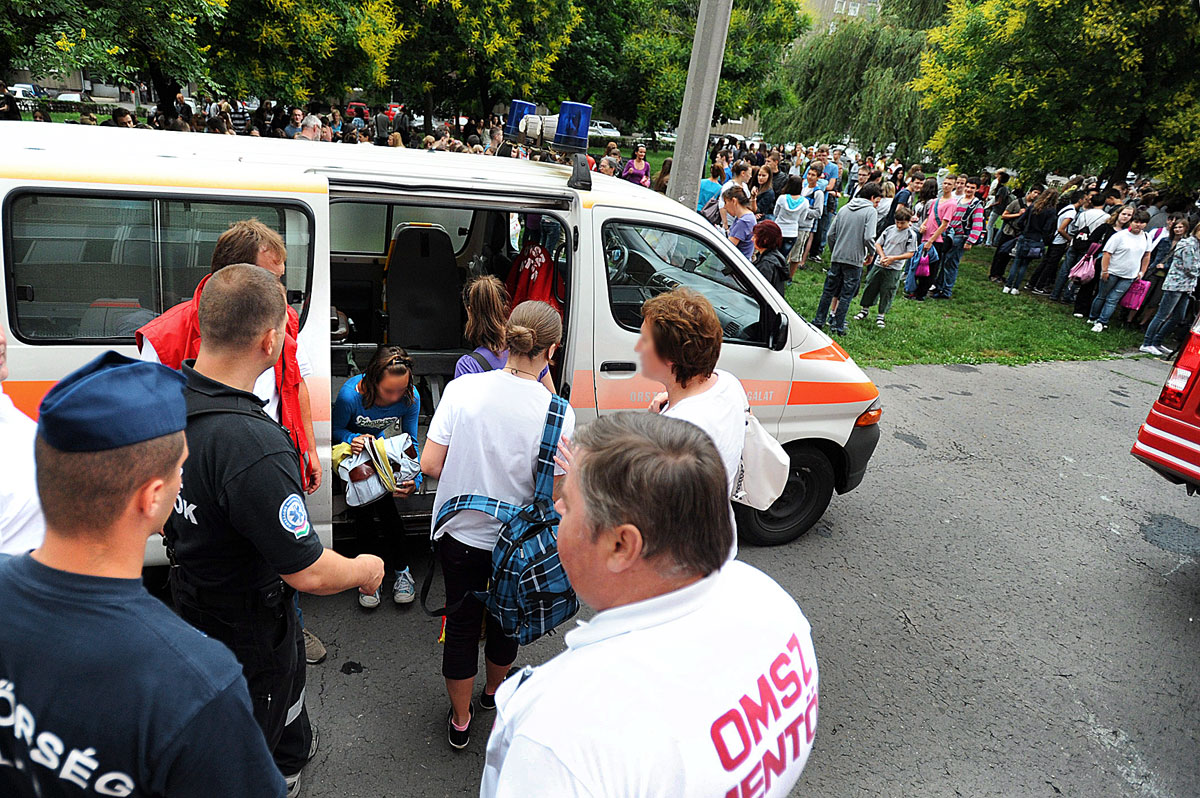 Mentők vizsgálják meg a diákokat a XX. kerületi Nagy László Általános Iskola és Gimnázium épülete mellett