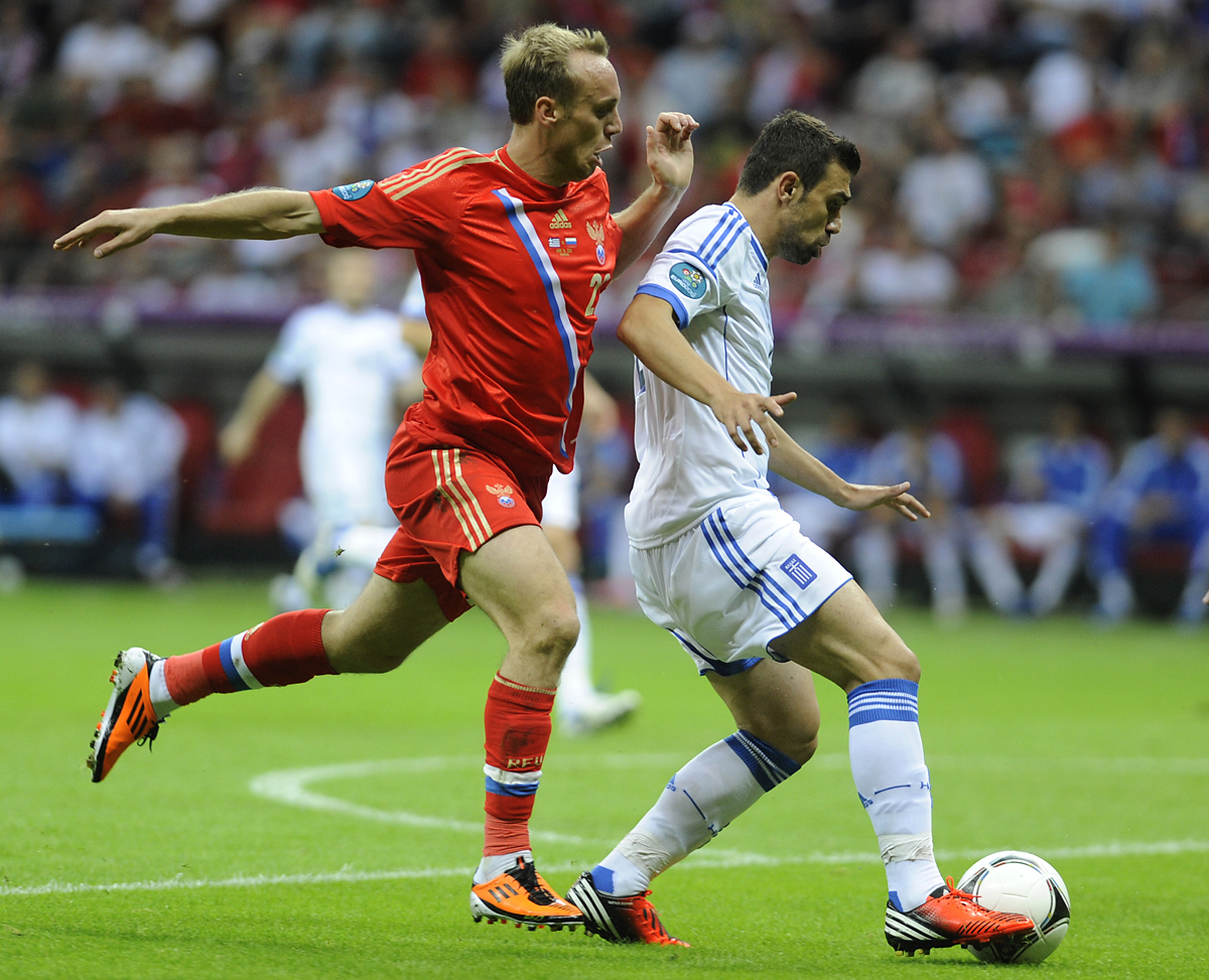 Greece's Giannis Maniatis (R) challenges Russia's Denis Glushakov during their Group A Euro 2012 soccer match at the National stadium in Warsaw, June 16, 2012. REUTERS/Pawel Ulatowski