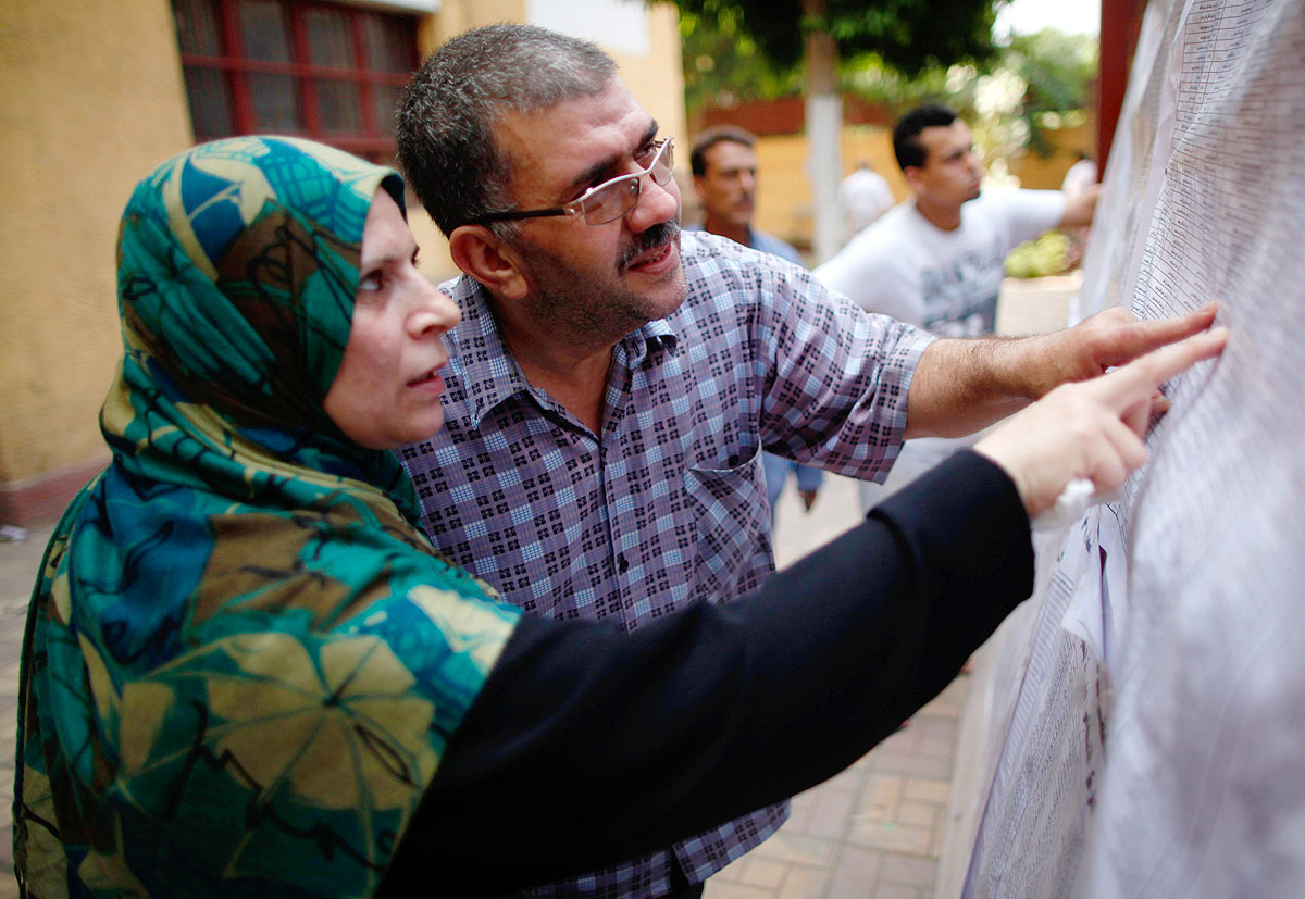 Voters check for their names before casting their votes during the second day of voting in Egypt's presidential election at a polling station in Cairo June 17, 2012. A second day of voting on Sunday will deliver Egypt's first freely elected president