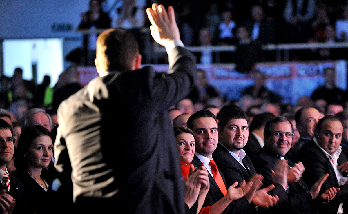 Vona Gábor (piros nyakkendőben) és Szegedi Csanád egymás mellett tapsol a Jobbik 2012-es évadnyitóján