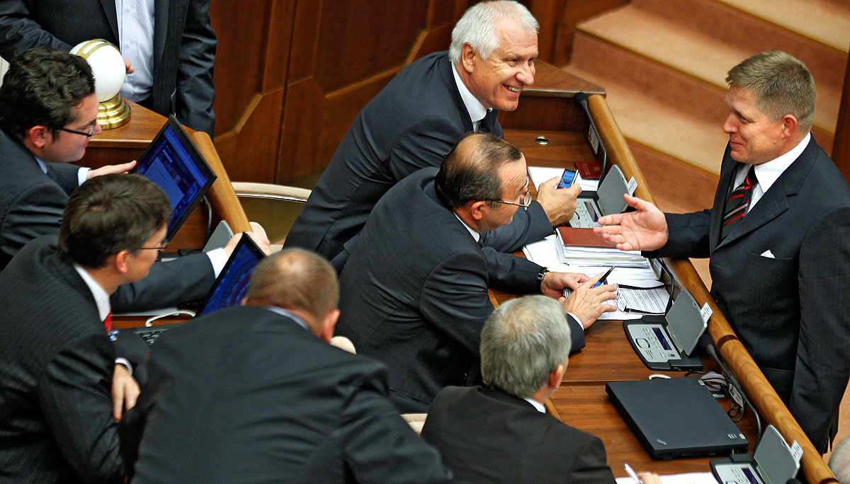 Robert Fico (jobbra) pártja képviselőit szórakoztatja a pozsonyi parlamentben