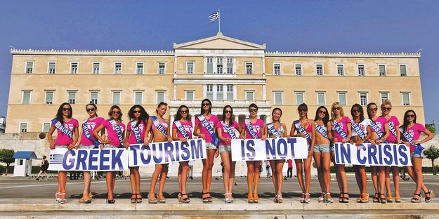 „A görög turizmus nincs válságban” – hirdetik egy szépségverseny résztvevői az athéni parlament előtt. A válság miatt már a tengerpartnak is elkel némi reklám