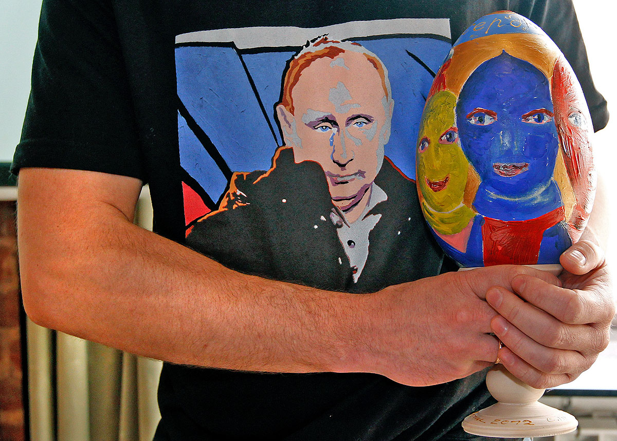 A Putyin-trikós performance-művész Alekszej Szergyenko, kezében Dmitrij Sagin a Pussy Riot tagjait ábrázoló fatojásával