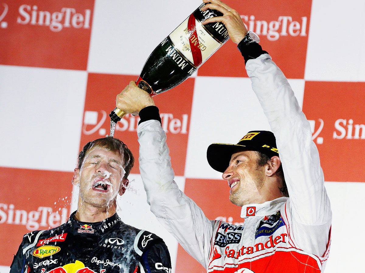 Pezsgő élet Szingapúrban... A brit Jenson Button locsolja a győztes német Sebastian Vettelt