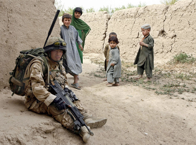 Brit katona pihenője figyelő gyerekekkel 2010-ben Helmand tartományban. A hadviselés szabályai