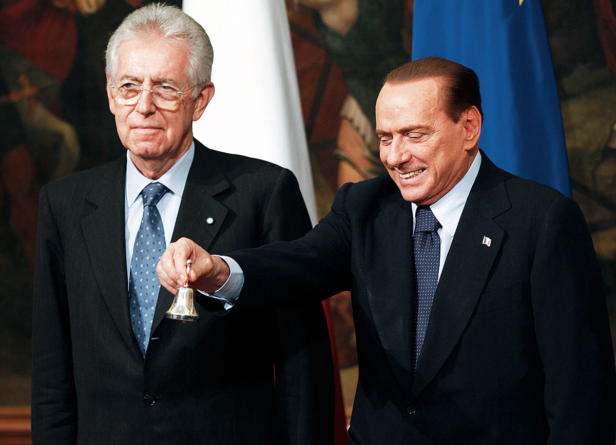 Silvio Berlusconi (jobbra) ezüstcsengővel jelezte Mario Monti (balra) kormányának első ülését 2011 novemberében. Mennének is, maradnának is