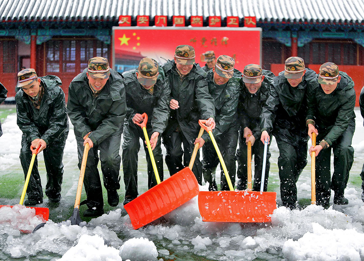 Rendőrök takarítanak havat a pekingi Tiltott Város előtt. Embereket foglalkoztató politikai kulcskérdés
