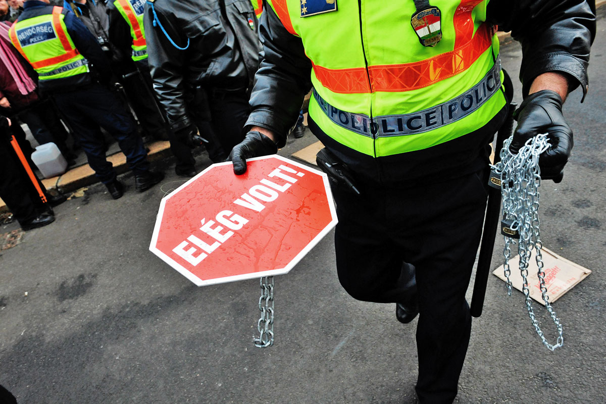 Amikor az LMP a láncait vesztette: a 2011. december 23-i tüntetésen egy rendőr a politikusoktól elkobzott kellékekkel 