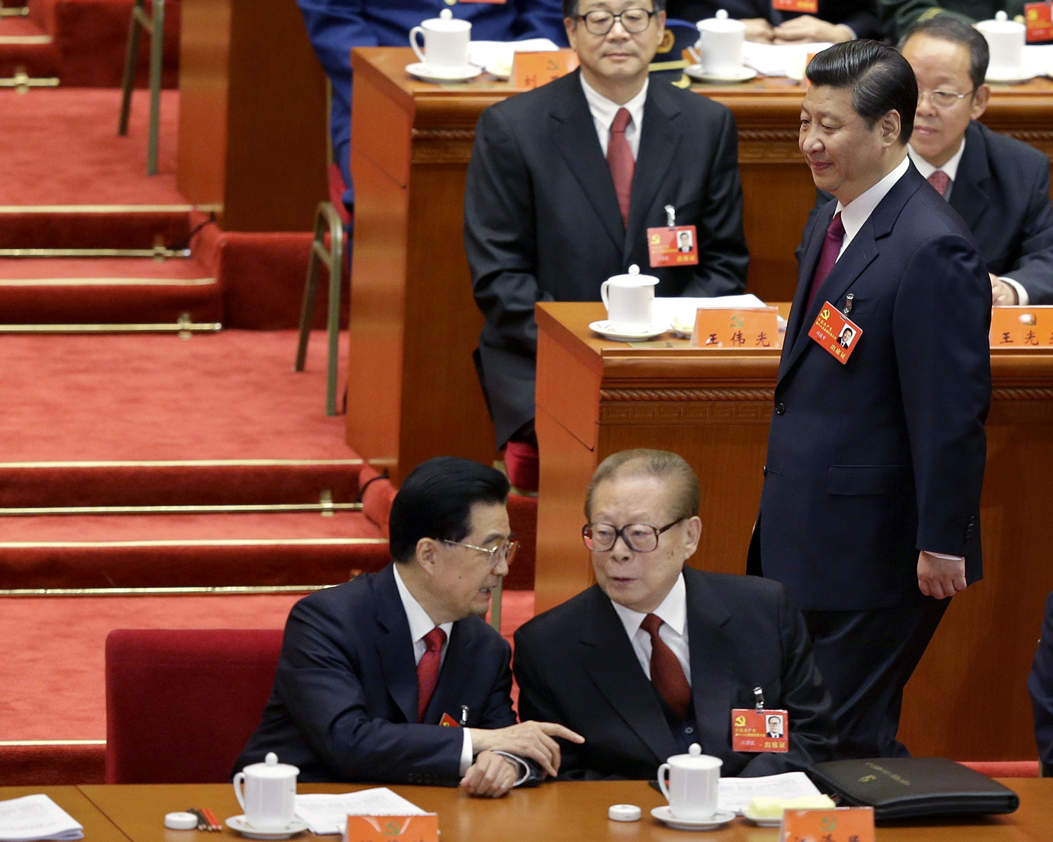 Három generáció: Hu Jintao távozó elnök beszélget elődjével, Jiang Zeminnel, miközben a pártelnöki posztot átvevő Xi Jinping megérkezik a terembe a 2012. novemberi pártkongresszuson