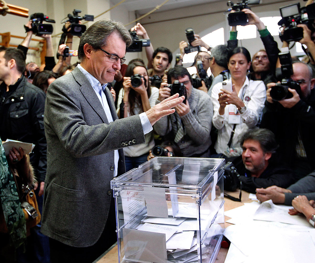 Convergencia i Unio (CIU) party's candidate Artur Mas casts his ballot for Catalunya's regional government surrounded by media at a polling station in Barcelona November 25, 2012. Spain's Catalans, angry over rising unemployment and persistent recess