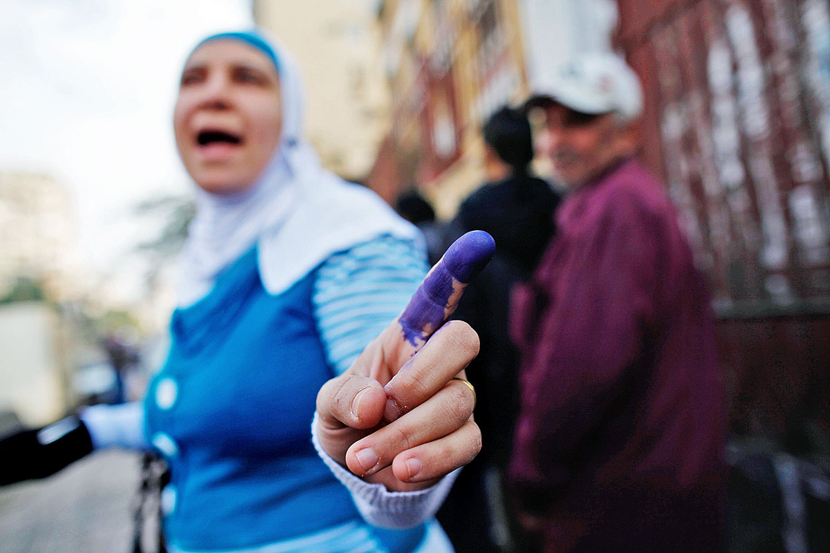 Egy nő mutatja a festékes ujját, miután leadta voksát