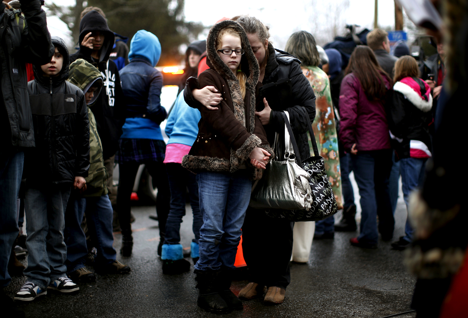 A Sandy Hook általános iskola előtt felállított improvizált emlékhelynél gyülekeznek Newtown lakói