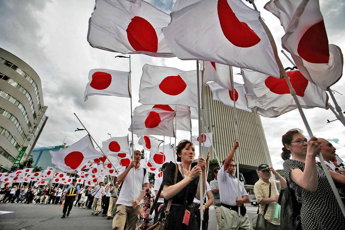 Nacionalista mozgalom tagjai japán zászlókkal vonulnak fel Japán második világháborús megadására emlékezve