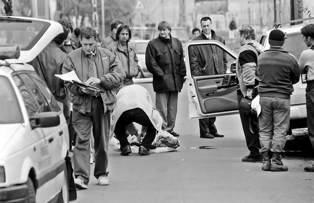 A szervezett alvilággal szoros kapcsolatban álló Prisztás Józsefet a nyílt utcán, fényes nappal lőtték le 1996 november elsején. A nyitott kocsiajtó mögött Doszpot Péter