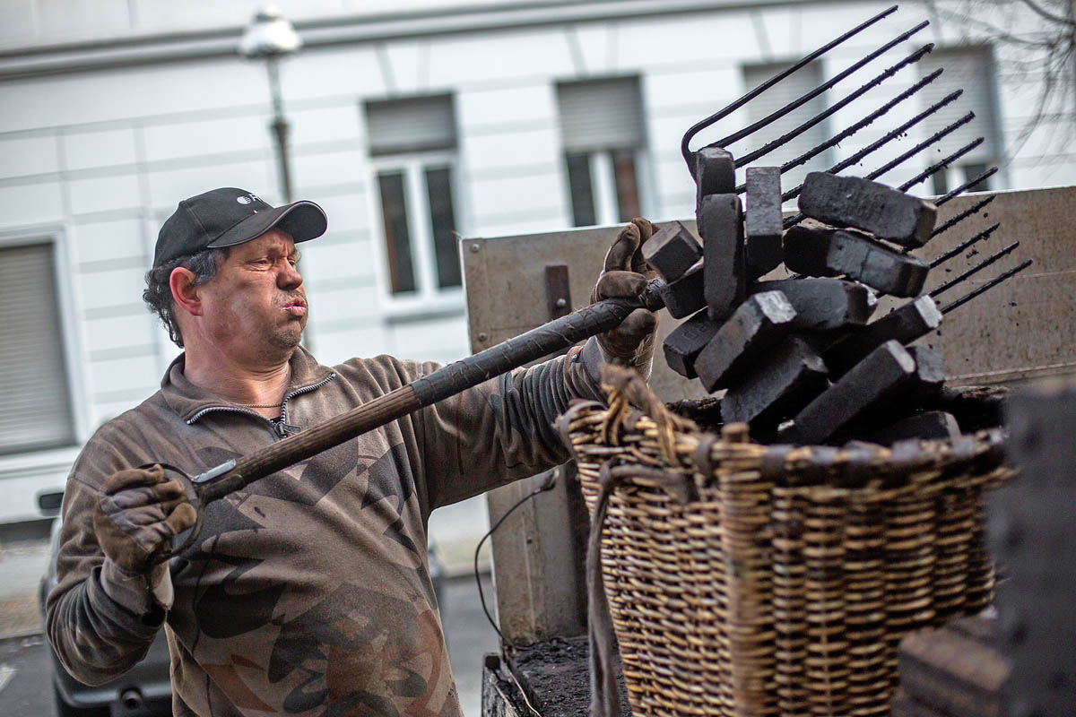 Henry Schulz 53 éves berlini szenesember brikettel tölti meg kosarát. Még harmincezer berlini lakást fűtenek szénnel