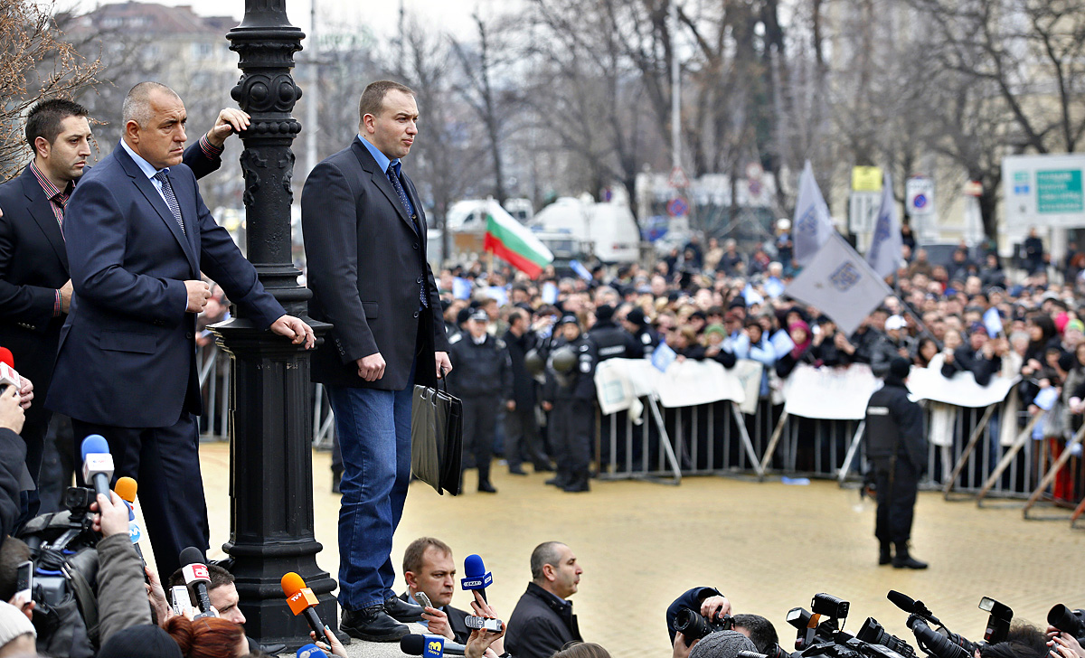 Boriszov távozó bolgár kormányfő (balról a második) nézi a tömeget a szófiai parlament épülete előtt