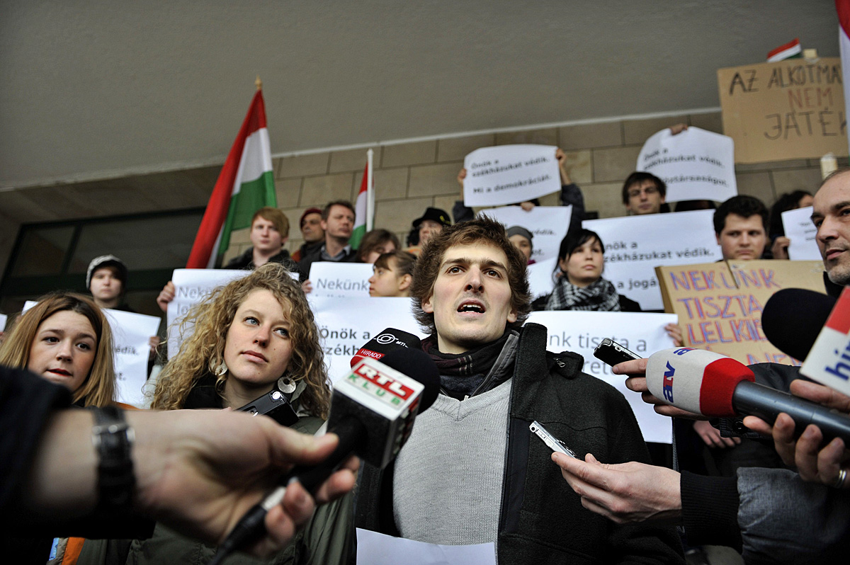 Papp Gáspár beszél a Fidesz-székház elfoglalóinak sajtótájékoztatóján a Képviselői Irodaház lépcsőjén