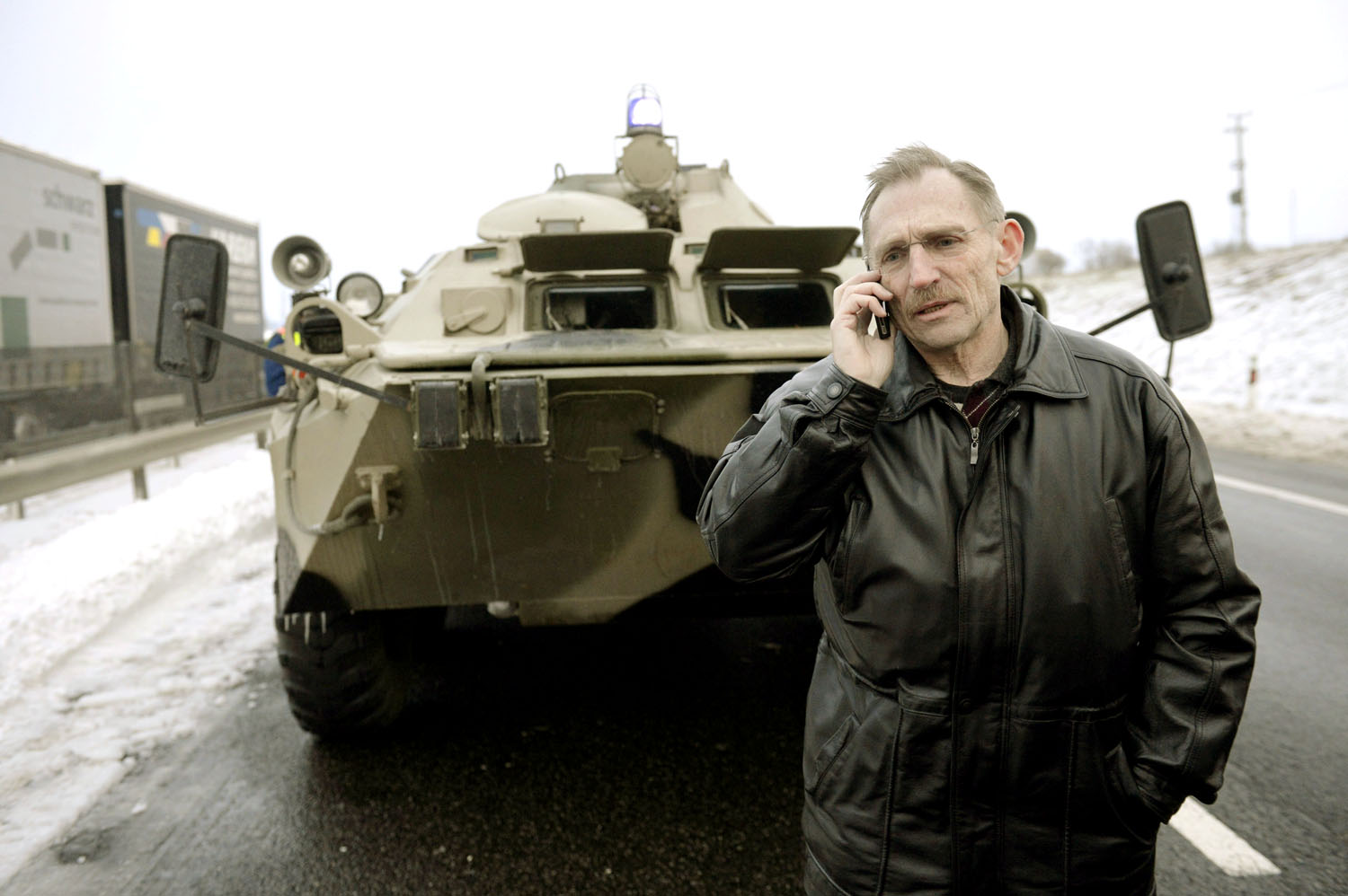 Pintér Sándor belügyminiszter egy páncélozott jármű előtt telefonál az M1-es autópályán