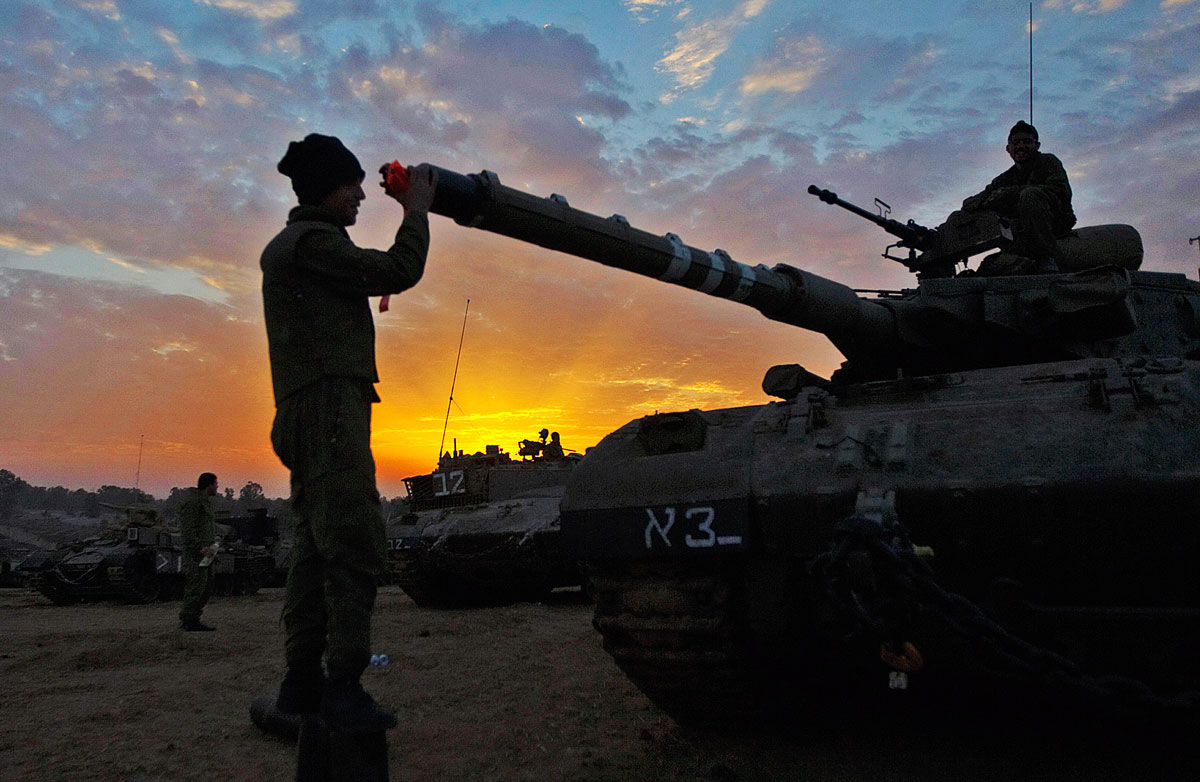 Izraeli katonai a Gázai övezet határánál, egy tank előtt