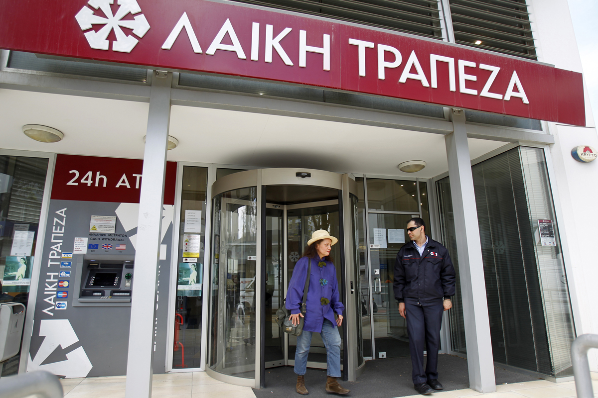 A woman leaves a branch of Laiki Bank shortly after it opened in Nicosia March 28, 2013. Cypriots queued calmly at banks as they reopened on Thursday under tight controls imposed on transactions to prevent a run on deposits after the government was f