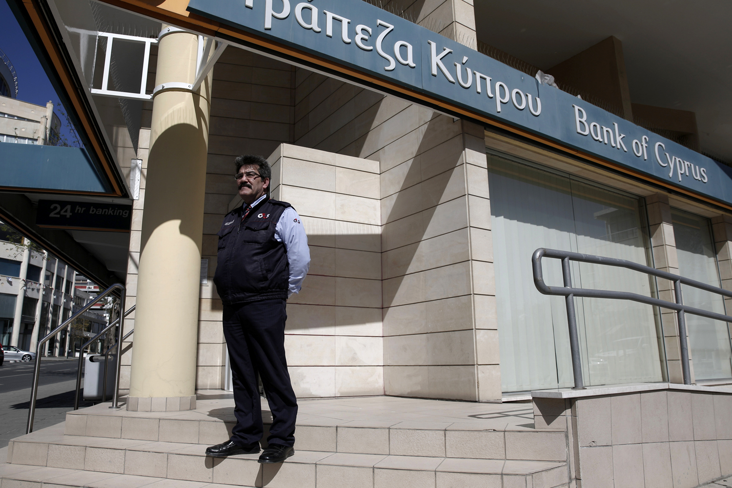 Biztonsági őr vigyáz a Bank of Cyprus egyik bezárt fiókjára