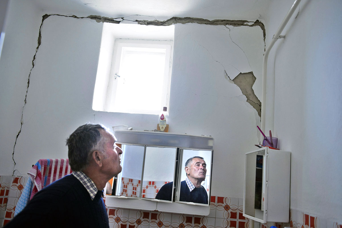 Hajnal József a földrengés következtében megrongálódott lakását mutatja Tenken