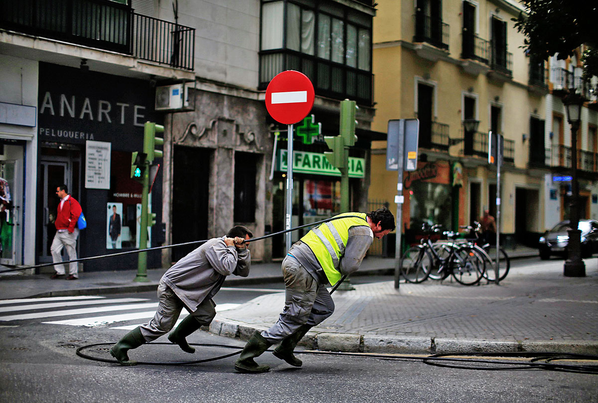 Nem kell megszakadni a megszorításokban – Sevillában munkások optikai kábelt fektetnek
