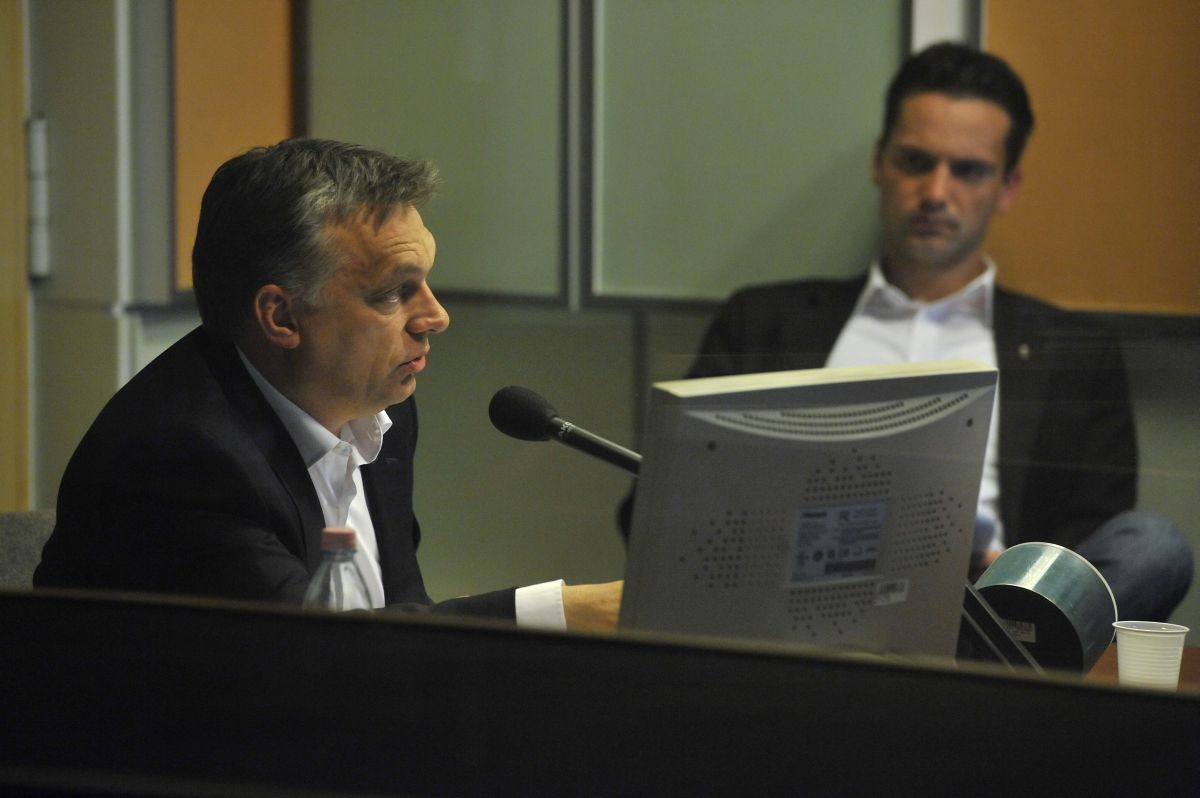 Orbán beszél, sajtófőnöke, Havasi Bertalan figyel