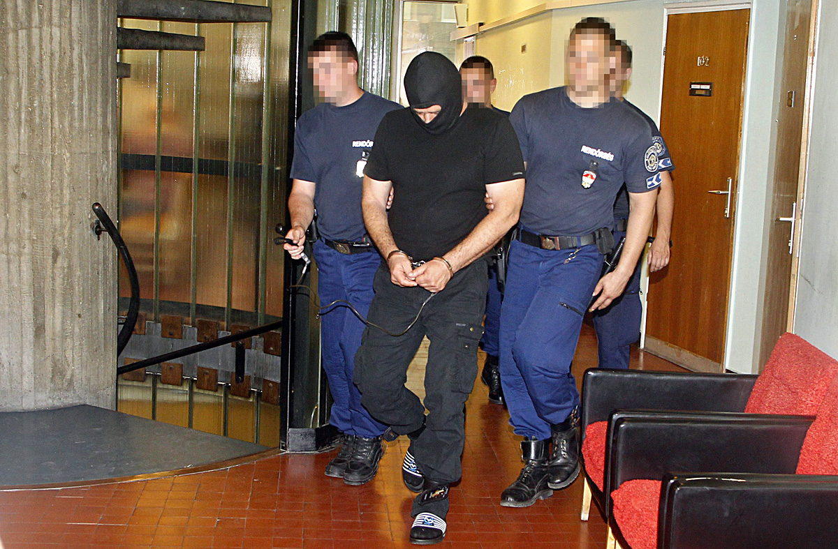 Rendőrök vezetik el M. Józsefet, akit előzetes letartóztatásba helyezett a Budakörnyéki Járásbíróság