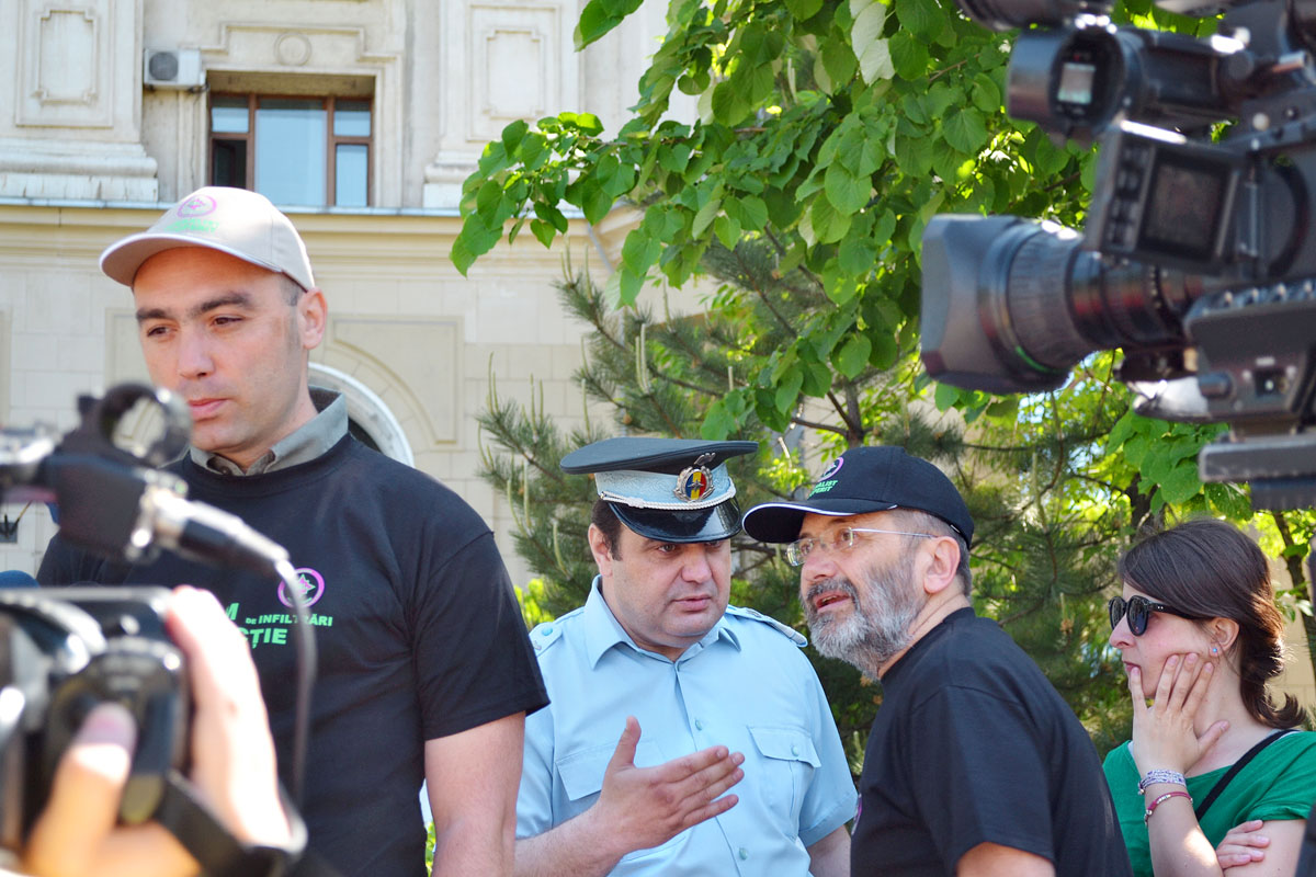 Mircea Toma, az ActiveWatch elnöke a hírszerzés székháza előtt posztoló rendőrrel tárgyal